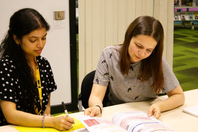 Students receiving tutoring in a library setting